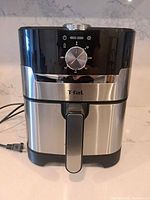 Front view showing stainless body, timer dial, basket handle