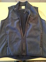 Front view of navy fleece vest, zipper open