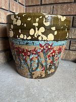Front view showing full pot, floral artwork, peeling paint