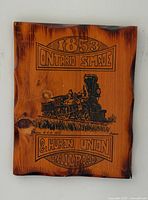 Front view of live-edge wooden plaque with steam locomotive graphic