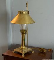 Full view of brass table lamp with shade, chimney, base and cord