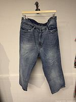Front view of blue denim jeans hanging