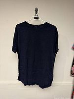 Front view of navy blue National Standards T-shirt on hanger