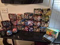 Front view of all tins, Poké Ball containers, carry box, binder and trays arranged on table