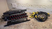All equipment arranged on countertop: TP-Link switch, two ADJ power centers, KVM switch and bundled yellow-headed KVM cables