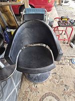 Front view of black vinyl barber chair on chrome base