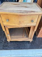 Front view showing overall form, drawer, hardware, and open shelf