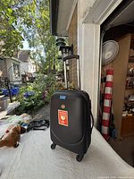 Front view of black hard-shell carry-on suitcase with telescopic handle extended