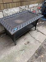 Full view of wicker coffee table with glass top and bottom shelf