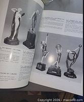 Open catalog pages displaying bronze and ivory sculptures