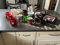 All mugs, grinder, pour-over cones and framed prints on countertop