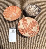 overview of three handmade bowls showing size relative to lot tag
