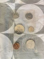 Obverse view of six sealed coins in plastic