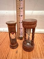 Two hourglasses beside ruler showing height