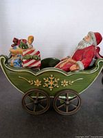 Green train car with Santa and gifts, right side view showing wheels and snowflake motif