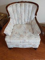 Front view of the Victorian upholstered armchair showing floral fabric, wood frame, cushion, and cabriole legs