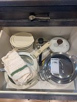 Cookware pieces and lids stored in drawer