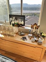 Overall view showing lanterns, candlesticks, triptych icon, glass apples and trinket boxes on wooden surface