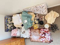 Assorted folded tablecloths, table protector, placemats, coasters, napkin rings visible in pile
