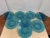 Set of eight blue Wheaton Glass presidential plates arranged to show quantity and color