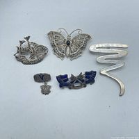 Five sterling silver pins laid out