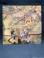 Front album cover showing band members in nature scene