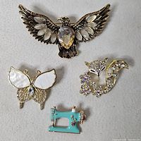 All four brooches displayed on fabric background