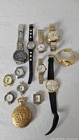 Group shot of all 13 watches laid on white cloth