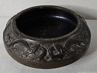 Oblique view of bowl showing exterior dragon relief and rim chip