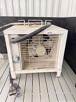 Front view of heater showing grille, fan, and attached power cord