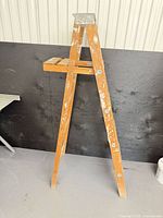 Full view of wooden folding step ladder front side