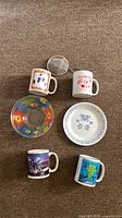 All six items laid out: three mugs, bowl, plate, strainer