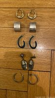All six earring pairs laid out on wood surface