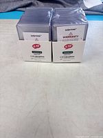Front view of two sealed LaSprintal toploader packs showing branding and warranty insert