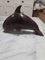 Left side view of carved dark brown wooden dolphin