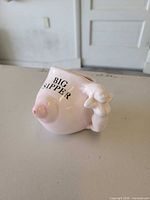 Side view showing breast form, nipple, "BIG SIPPER" text and handle