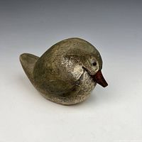 Three-quarter side view of carved bird showing form and paint