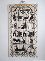 Full view of wool wall hanging showing entire embroidered scene and wood mounting bar