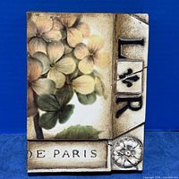 Front view of Sid Dickens Memory Block showing flower image, raised letters, rosette, and text band