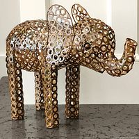 Front angled view of metal ring elephant sculpture showing trunk, ears, and open-work ring body