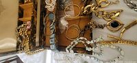 Open jewelry box showing assorted bracelets, pendants, bead necklaces