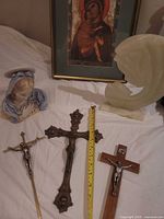 Group shot of all items: three crucifixes, ceramic Mary bust, onyx sculpture, framed print