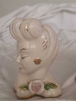 Cream lady head vase side view showing gold accents and rose
