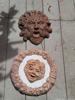 Brown terracotta open-mouth face mask and round child face plaque