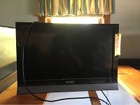 Front view of Vizio 26-inch TV showing screen and base with power cord coiled in front.