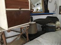 View of antique metal scale, wooden breadbox, small wooden stool, ceramic thermal jug, decorative vase, and old metal tray