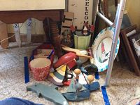 View of wooden ships, lighthouse plate, dolphin figure, and other nautical decor pieces on carpet floor under table.