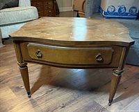 Angled view of end table showing drawer front, tapered legs and casters