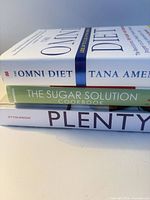 Spine view of all three hardcover cookbooks stacked