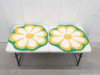 Both matching daisy mats displayed on table